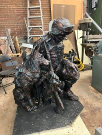 brass sculpture of veteran and dog